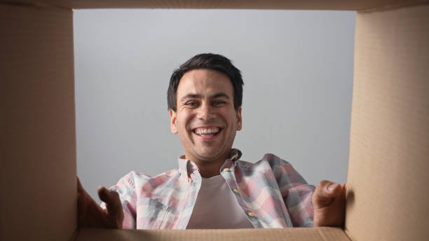 istock Happy person open box. Excited man unpack parcel. Guy look into package. Unbox 1740548998