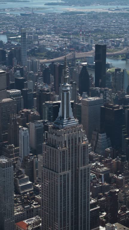 Vertical Screen: New York City Business Center From Above. Footage of a Famous Art Deco Skyscraper. Helicopter View on an Impressive Tourist Landmark. Manhattan Panorama with Empire State Building