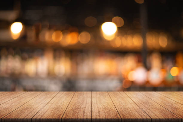 istock Empty wooden table top with lights bokeh on blur restaurant background. 1740562763
