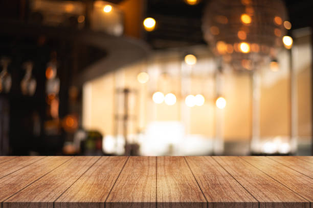 istock Empty wooden table top with lights bokeh on blur restaurant background. 1740562773