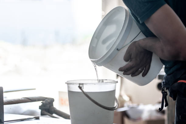 istock Pouring transparent epoxy resin from one bucket to another 1740570638