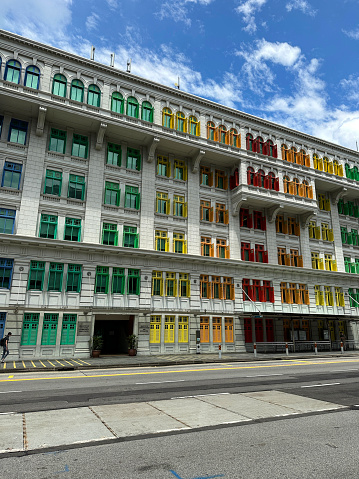 Hill Street, Downtown Core, Singapore - February, 10 2023: Stock photo showing view of the MICA Building (Ministry of Information Culture and the Arts) the former Old Hill Street Police Station with window frames and shutters painted to form the rainbow spectrum.