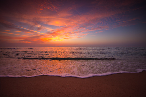 Beautiful sunrise over the sea shore and beach sand.