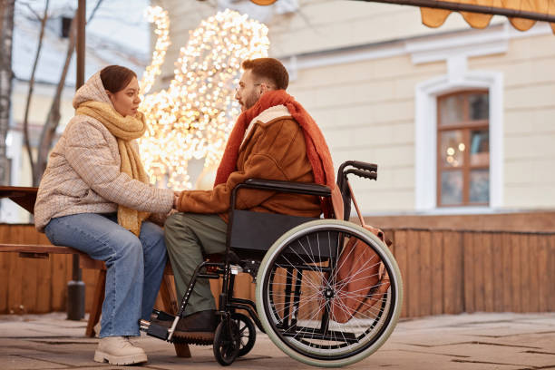 istock Young man with disability holding hands with girlfriend during date in winter 1740607362