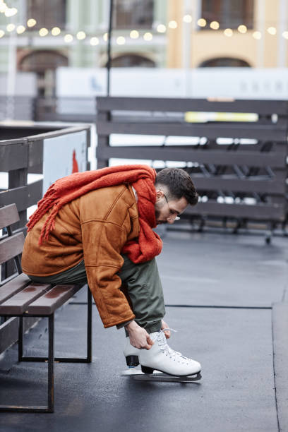 istock Man putting on skates in ice skating rink 1740608509