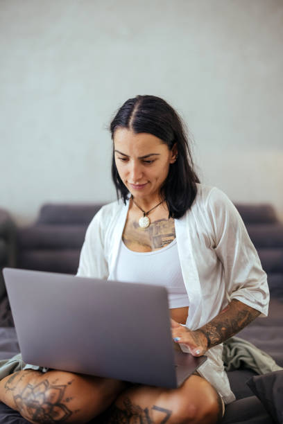 istock Young woman uses laptop in bed 1740615462