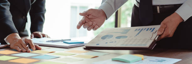 istock Business colleagues reading data in sticky notes and document while coworking about new business 1740625773