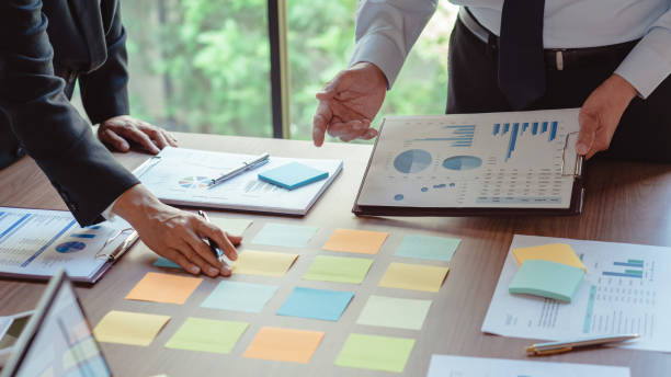 istock Business colleagues reading data in sticky notes and document while coworking about new business 1740625800