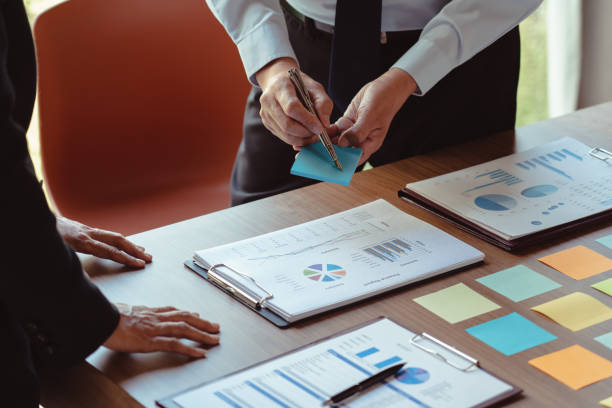 istock Business colleagues discussing and writing data in sticky notes while coworking about new business 1740625802
