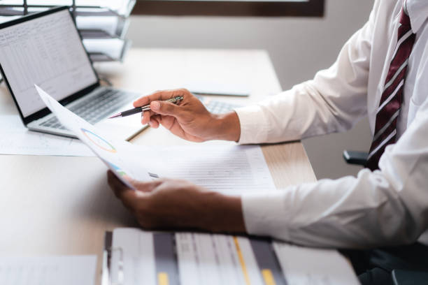 istock Businessman reading marketing paper and checking data on laptop while analyzing strategy of startup 1740626388