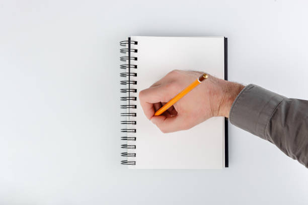 istock business notepad, hand holding a pencil on a white background 1740629915