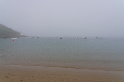 Light sea mist shrouds the bay at the coastal village of Porthdinllaen on a summer afternoon in June