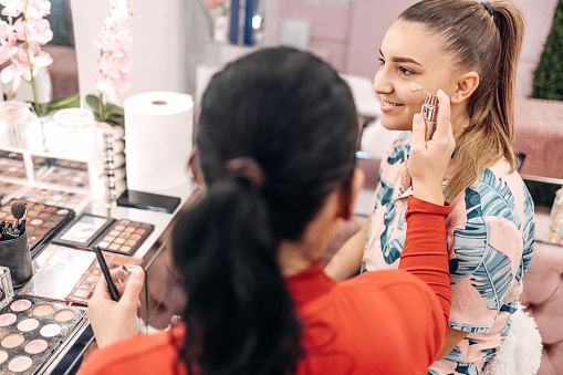 Young woman starting small business doing make-up to client