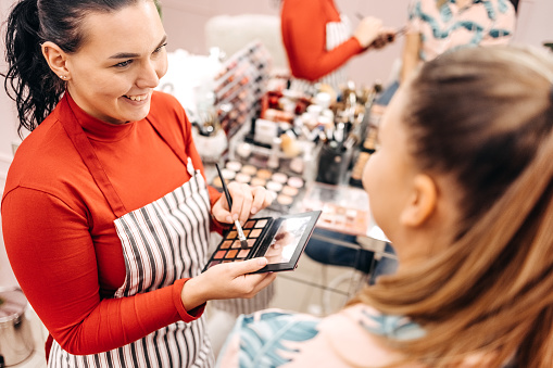 Young woman starting small business doing make-up to client