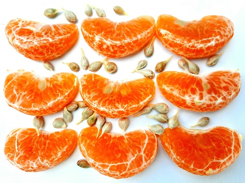Orange fruit and seeds - white background.