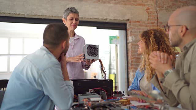 Electronics professor teaching students about computer parts