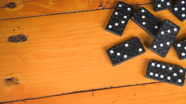 stapel schwarzer klassischer dominosteine auf hölzernem tischhintergrund. domino-spielkonzept. leerer textbereich für die kopie - domino sport leisure activity group of objects stock-fotos und bilder