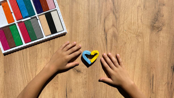 istock Creative playing with baby play dough, hands holding hand-made plasticine toy, making plasticine figures 1740669896