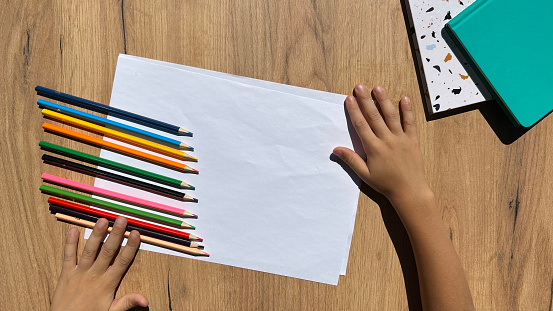 Children's drawing with colorful pencils on clean paper