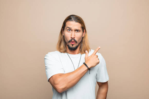 istock Portrait of surprised man pointing at copy space 1740676189