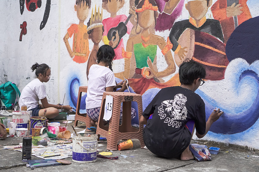 Yogyakarta, Indonesia - August 8, 2023: A young artist is having a competition to draw a mural on the wall with the theme of the 78th Independence Day of the Republic of Indonesia.