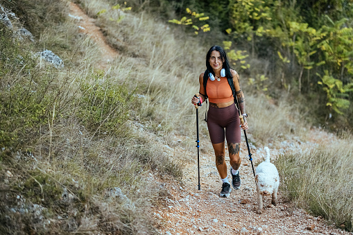 Young woman hiking on the mountain with her dog