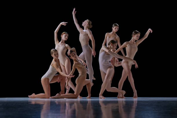 istock Talented, beautiful, artistic young people in motion, ballet dancers making creative performance against black background. 1740699273