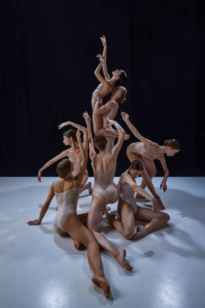 istock Pyramid. Young talented, artistic people, talented and artistic ballet dancers performing against black background. 1740699404
