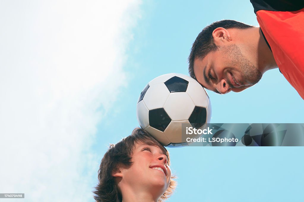 Vater und Sohn Fußball-Ball auf Stirn mit Wolkenmotiv - Lizenzfrei 12-13 Jahre Stock-Foto