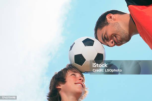 Vater Und Sohn Fußballball Auf Stirn Mit Wolkenmotiv Stockfoto und mehr Bilder von 12-13 Jahre