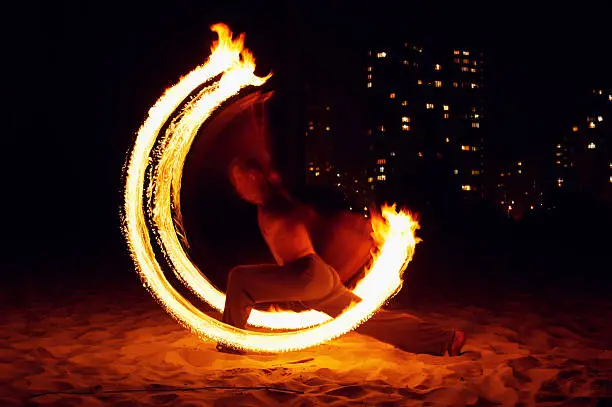 Male acrobat performs flame show.