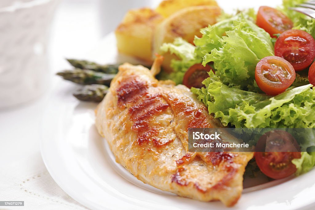 Bistecca di pollo alla griglia con patate, asparagi e insalata - Foto stock royalty-free di Asparago