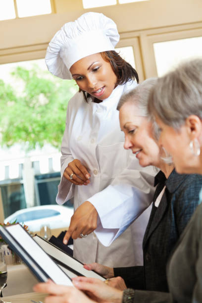 istock Restaurant chef helping customers with menu food questions 174071586
