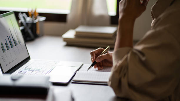istock Female entrepreneur working to analysis strategy of startup project and writing ideas down notebook 1740718251