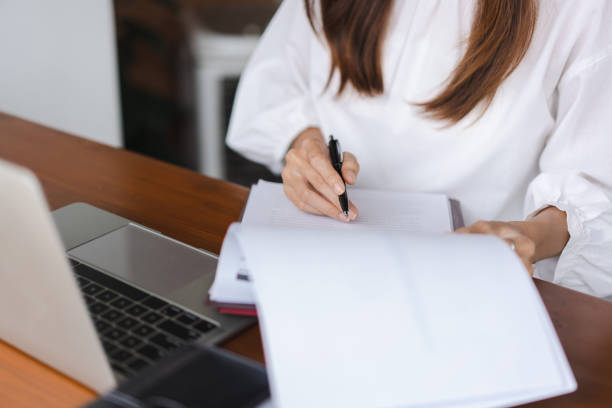 istock Businesswomen reading data on laptop and checking finance document while working in outside office 1740718634