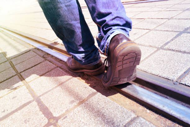 istock Man walking on tram rail into bright ligt 174072467