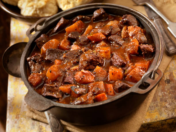 Irish Stew with Biscuits "Braised Lamb Stew with Potatoes, Onions and Carrots in a Cast Iron Pot- Photographed on Hasselblad H3D2-39mb Camera" skillet cooking pan photos stock pictures, royalty-free photos & images