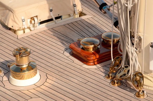 A detail of the deck of a luxury classic sailing boat. Various ropes and pulleys.
