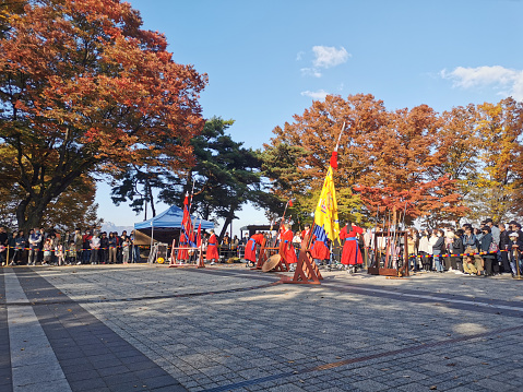 Seoul, South Korea - October 23, 2022: Traditional Korean Kingdom Soldier Warriors walks to guard among group of tourists in Namsan Mountain