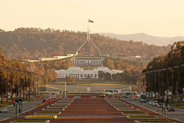 "The old and new parliament houses of Australia, seen down Anzac Parade in Canberra around  sunset."