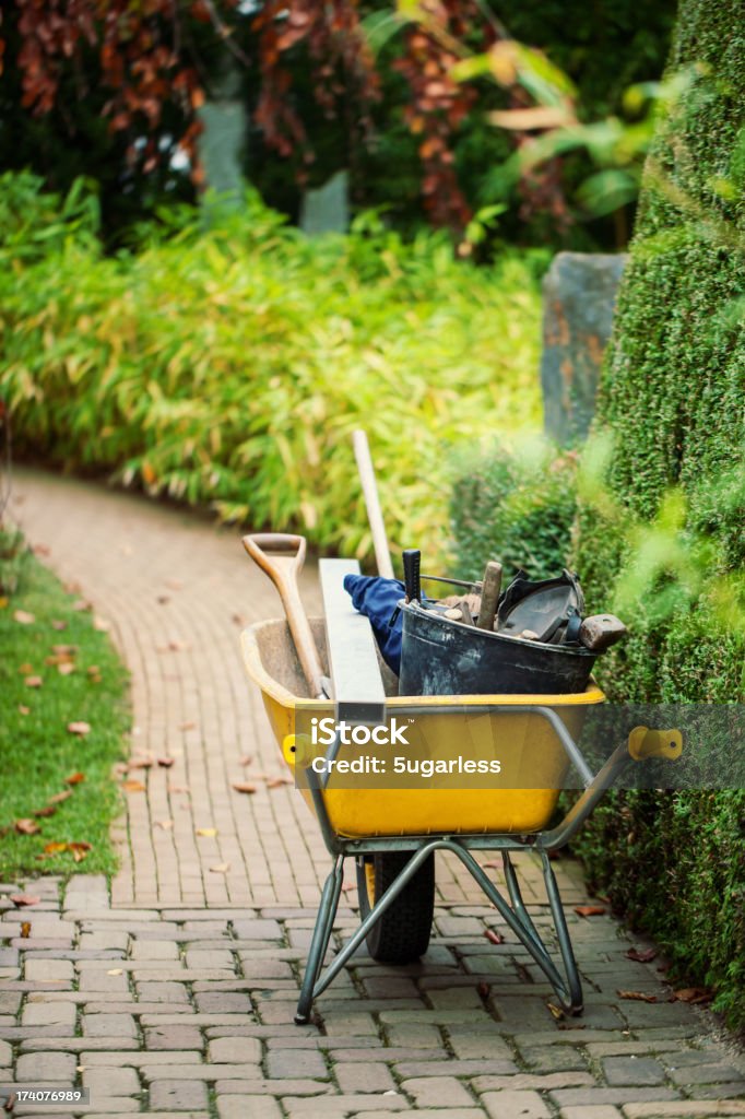 Wheelbarrow with instruments in a garden Wheelbarrow with garden instruments Wheelbarrow Stock Photo