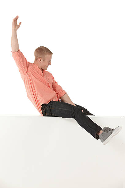 istock Man sitting on the ledge of a wall and gesturing 174079380