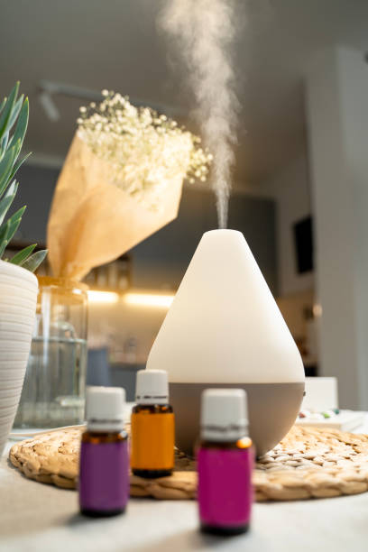 istock Air diffusor standing on kitchen table, air purification concept, essential oils in bottles next to it 1740797014