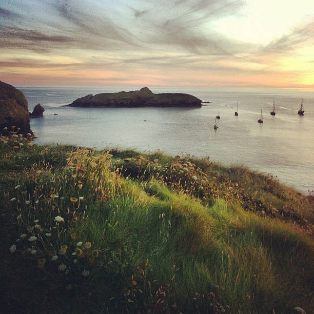 Sunset at Mullion Cove, Cornwall, England "Sunset from the top of the mountain at Mullion Cove, Cornwall, England. iPhone pic. Mullion Cove is a harbour on the Lizard peninsula in south Cornwall, United Kingdom" mullion cove stock pictures, royalty-free photos & images