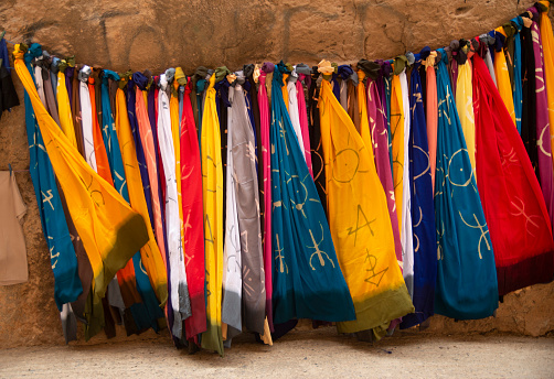 Many colourful Moroccan scarves with berber symbols in street market
