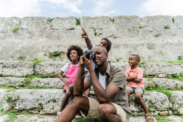 Mid adult man taking photos with his family outdoors
