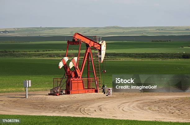 Vista Panoramica Di Un Rosso Pompa Jack In Un Grande Campo Di Grano - Fotografie stock e altre immagini di Petrolio