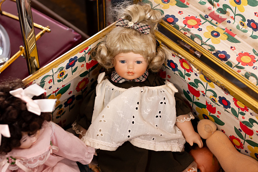 Vintage dolls in the old chest in antique market.