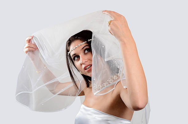 istock Beautiful Bride Lifting Veil And Looking Up 174084475