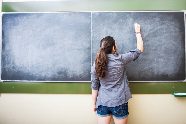 istock Teenage student is writing on the blackboard. 174084658